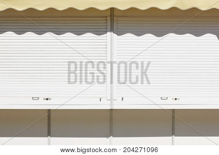 Closed blind with canopy on an outdoor shop. Horizontal
