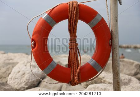 Big Red Buoy On The Rocks To Help Swimmers