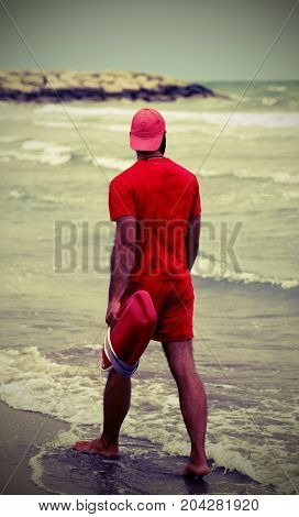 Muscular Lifeguard With Red Uniform