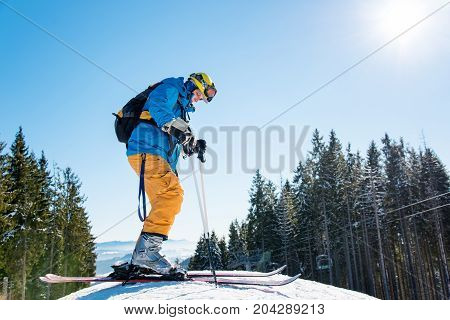 Low Angle Shot Of A Man Skiing In The Mountains, Wearing Skis, Enjoying Sunny Winter Day Outdoors Co