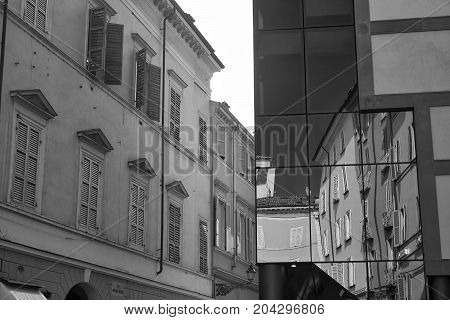 Parma (Emilia Romagna Italy): old and modern buildings in the Cesare Battisti square. Reflections. Black and white