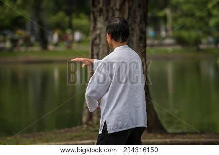 Man Exercising By Tai Chi In A Outdoor Park