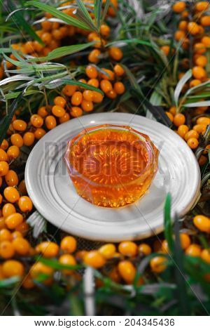 bunches of ripe orange sea-buckthorn on branches with sea-buckthorn oil.