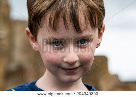 View of Young little boy portrait looking and smiling at the camera.