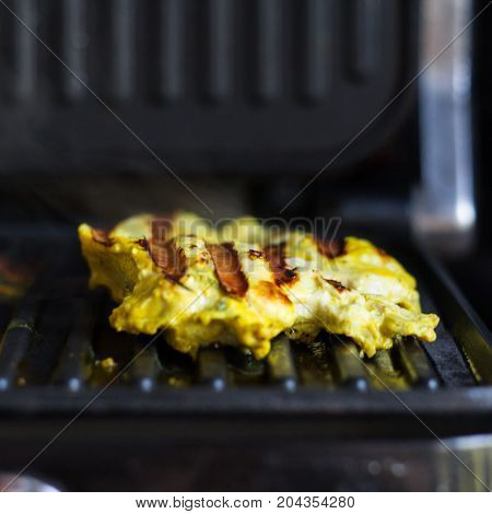 The turkey steak with curry on grill