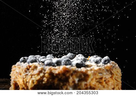 layered cake, Napalion cake, puff cake with blueberry sprinkled with powdered sugar, on a rough wooden backing, menu background