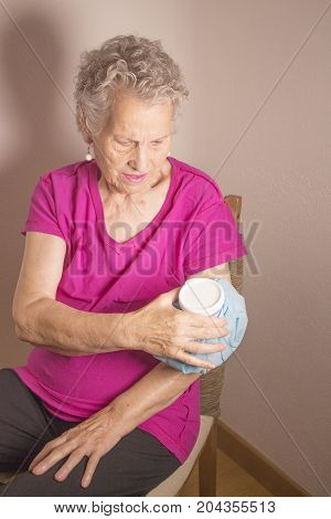 Ice pack on older woman arm to relieve pain