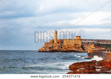 Fortress and lighthouse of El Morro in the entrance of Havana bay Cuba. Sunset after storm.