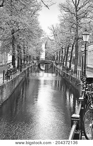 Urban scene in Amersfoort with typical local architecture and many bicycles. Street View with bikes parked on an embankment in the historical center of Amersfoort in the Netherlands. Black and white picture