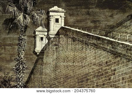 View on a fortification of an old city Akko in Israel. The ancient fortress of Acre with guard towers. Vintage style toned picture