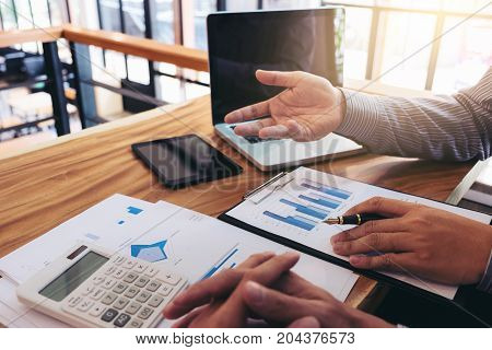 Co working conference Business team meeting present investor colleagues discussing new plan financial graph data on office table with laptop and calculator Finance accounting investment.