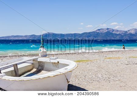 Small boat is dry docked withdrawn at the beach coastline.