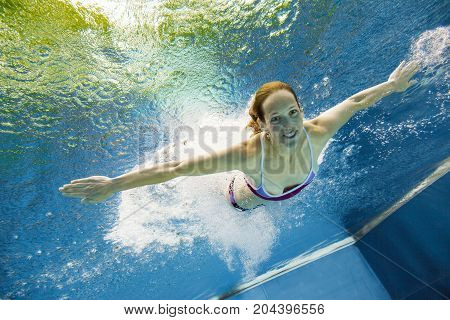 a young woman is jumping into the water from a diving plattform