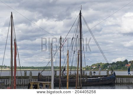 Roskilde Denmark - August 01 2015: replica of ancient boat and visitors outside the Vicking Ship Museum