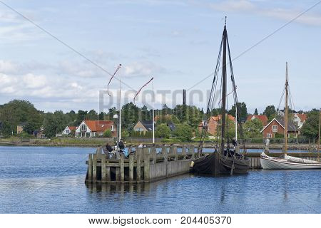 Roskilde Denmark - August 01 2015: replica of ancient boat and visitors outside the Vicking Ship Museum