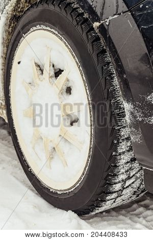 Car wheel with snowy winter tire. Car tyre for winter.