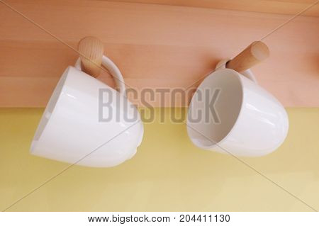 Cuisine and Food Two White Ceramic Coffee Cup Hanging on The Wall Used for Preparing and Drinking Coffee.