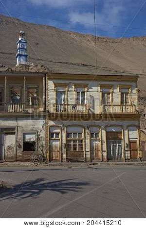 Pisagua, Tarapaca Region, Chile - August 21, 2017: Historic wooden buildings from the era of nitrate mining in the Atacama Desert, in the coastal town of Pisagua in northern Chile.