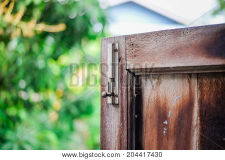 A latch of bar lock at the old wooden window. Protect Anti-theft Protection.