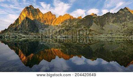 Sunrise in High Tatras in Slovakia. Monumental peak Prostredny hrot. Summer scenic landscape mountain view. Alpine trail. Small cold valley with Prostredne Spisske tarn.