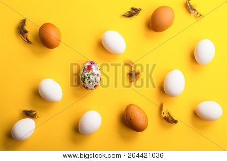 Fresh raw brown and white eggs over yellow background. Space for text