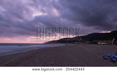 Sunset over Castelldefels beach in summer with clouds