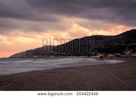 Sunset over Castelldefels beach in summer with clouds