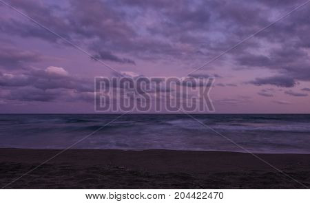 Sunset over Castelldefels beach in summer with clouds