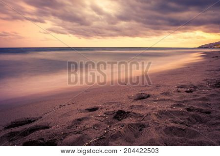 Sunset over Castelldefels beach in summer with clouds