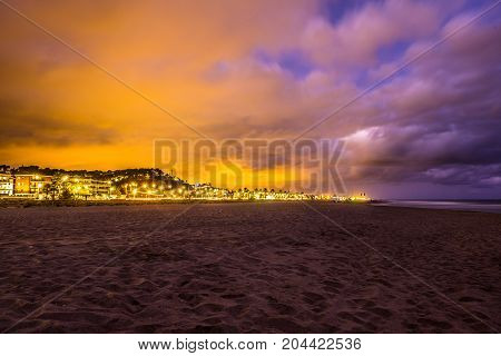 Sunset over Castelldefels beach in summer with clouds