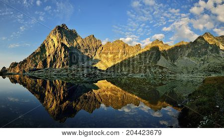 Sunrise in High Tatras in Slovakia. Monumental peak Prostredny hrot. Summer scenic landscape mountain view. Alpine trail. Small cold valley with Prostredne Spisske tarn.