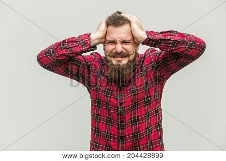 Terrible Headache. Young Adult Man Touching His Head With Hands And Making Face