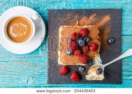Tiramisu cake with raspberries and blueberries. Homemade tiramisu dessert. Traditional Italian cuisine