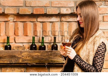 Woman Tasting Wine In Rural Cottage Interior