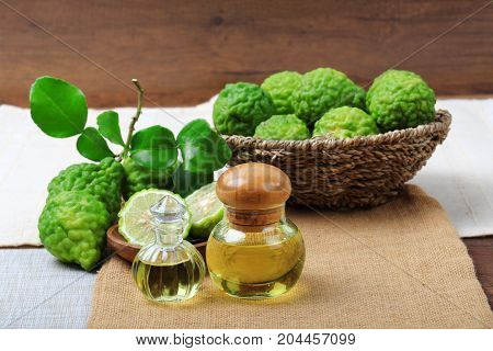 Kaffir lime or bergamot with aromatic spa of bottles essential oil on sack background.