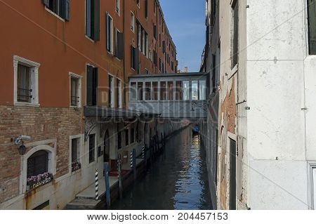 Traditional gondola ride in small canal at residential district of historical buildings and bridge, Venezia, Venice, Italy, Europe