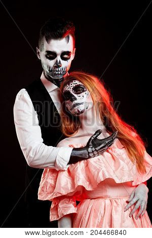 A classy couple, wearing skull make-up for. All souls day. Boy and girl in costumes of skeletons and sugar skull makeup