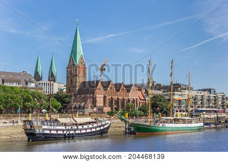 BREMEN, GERMANY - AUGUST 23, 2017: Historical ships and church along the river Weser in Bremen Germany