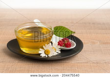A Cup Of Honey On The Plate. The Honey In The Spoon Drops, Raspberry, Chamomile, Derevyanny Backgrou