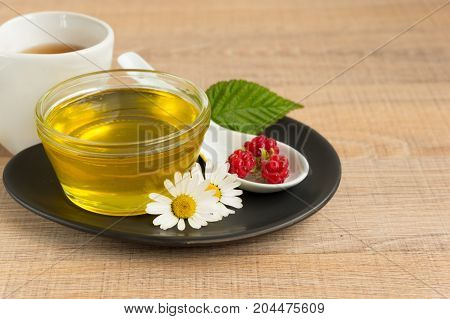 A Cup Of Honey On The Plate. The Honey In The Spoon Drops, Raspberry, Chamomile, Derevyanny Backgrou