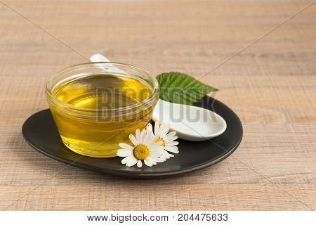 A Cup Of Honey On The Plate. The Honey In The Spoon Drops, Raspberry, Chamomile, Derevyanny Backgrou