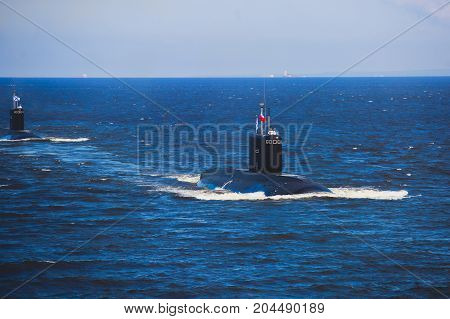 A line of modern russian military submarine cruisers in the row, northern fleet and baltic sea fleet in the open sea, submarine