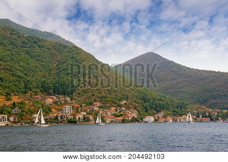Seaside village of Lepetane with boats sailing along the coastline. Bay of Kotor (Adriatic Sea), Montenegro, autumn