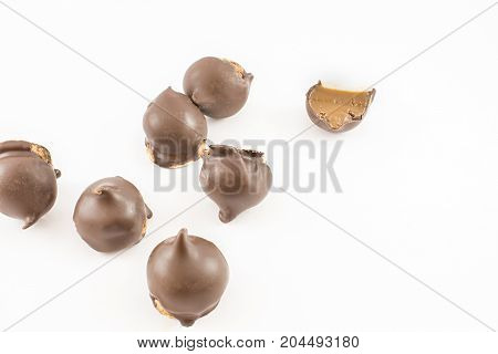 Many cones of dulce de leche and chocolate whole and cut in half. White background.