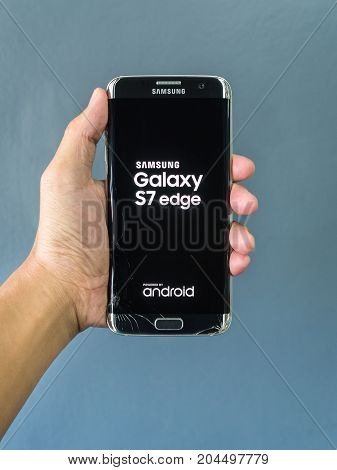 Chiangrai Thailand: September 2 2017 - Human hand holding broken smartphone and showing text 'SAMSUNG Galaxy S7 edge' and 'android' on screen