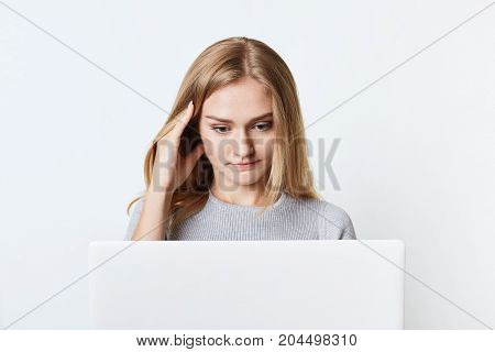 Concentrated Female Freelancer Works At Laptop Computer, Translates Article While Sits At Her Workpl