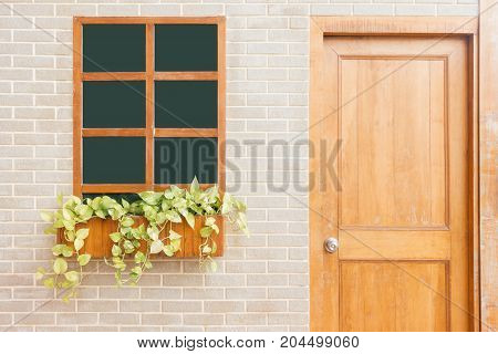 Wooden front door of a home. Front view of a wooden front door on a yellow house with reflections in the window and a wide view of the porch and front walkway. Horizontal shot.