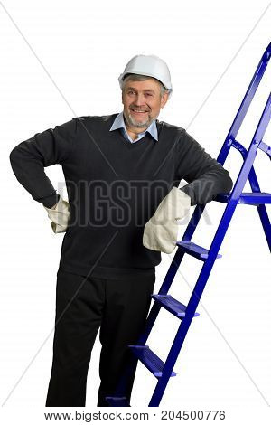 Happy mature foreman, white background. Handsome senior engineer standing and leaning on building ladder. Building inspector looking on building process.