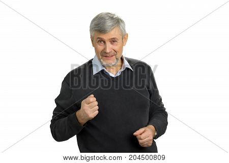 Angry mature man on white background. Portrait of senior man showing fist. Irritated mature man putting his fist up. Facial expressions, emotions and interpersonal conflict resolution.