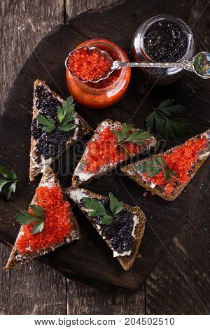 Red And Black Caviar In Small Silver Spoon On A Wood Background With Black Bread ,food Concept